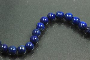 Lapis Lazuli spherical gemstone strand blue, approx. dimensions  6mm, approx. 39,5cm long. Quality feature A. This gemstone strand was provisionally strung on blue pearl silk for further processing.